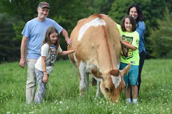 Tracey McShane family taking picture with cow.